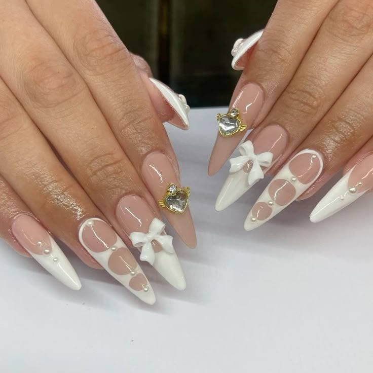 Nude and white nail art with bows and gold heart details